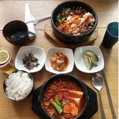 Kimchi stew with rice and beef bibimbap. Side dishes anchovies, kimchi (fermented cabbage) and pickles.